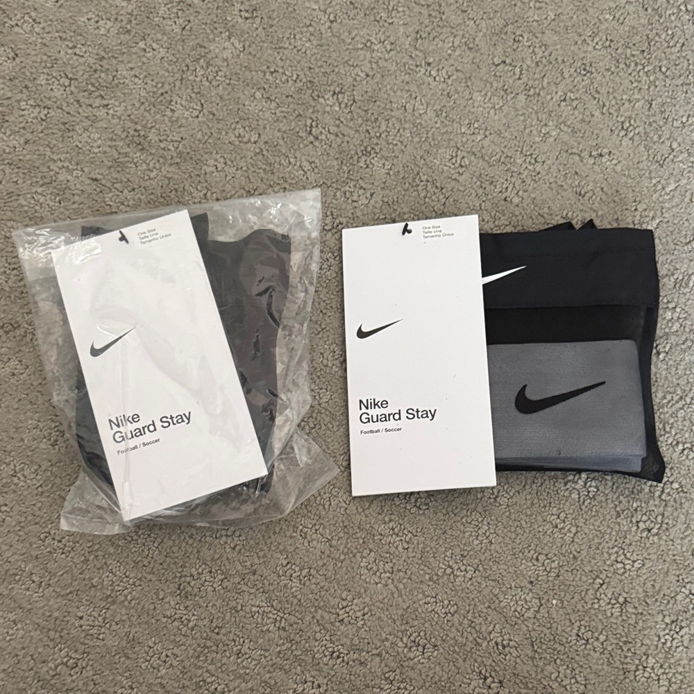 (2) Nike Guard Stay Shin Guard stay - one black and one white. Brand new OS